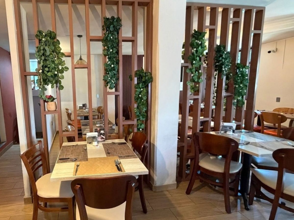 Mesas junto al separador de madera con plantas en El Yoyo